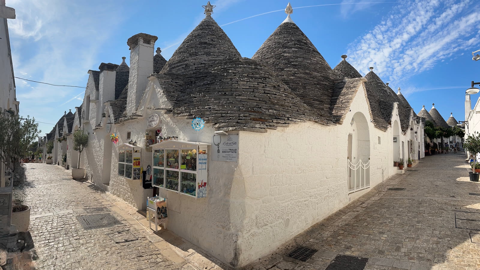 Gade i Alberobello med hvidkalkede trulli-huse og kegleformede stentage