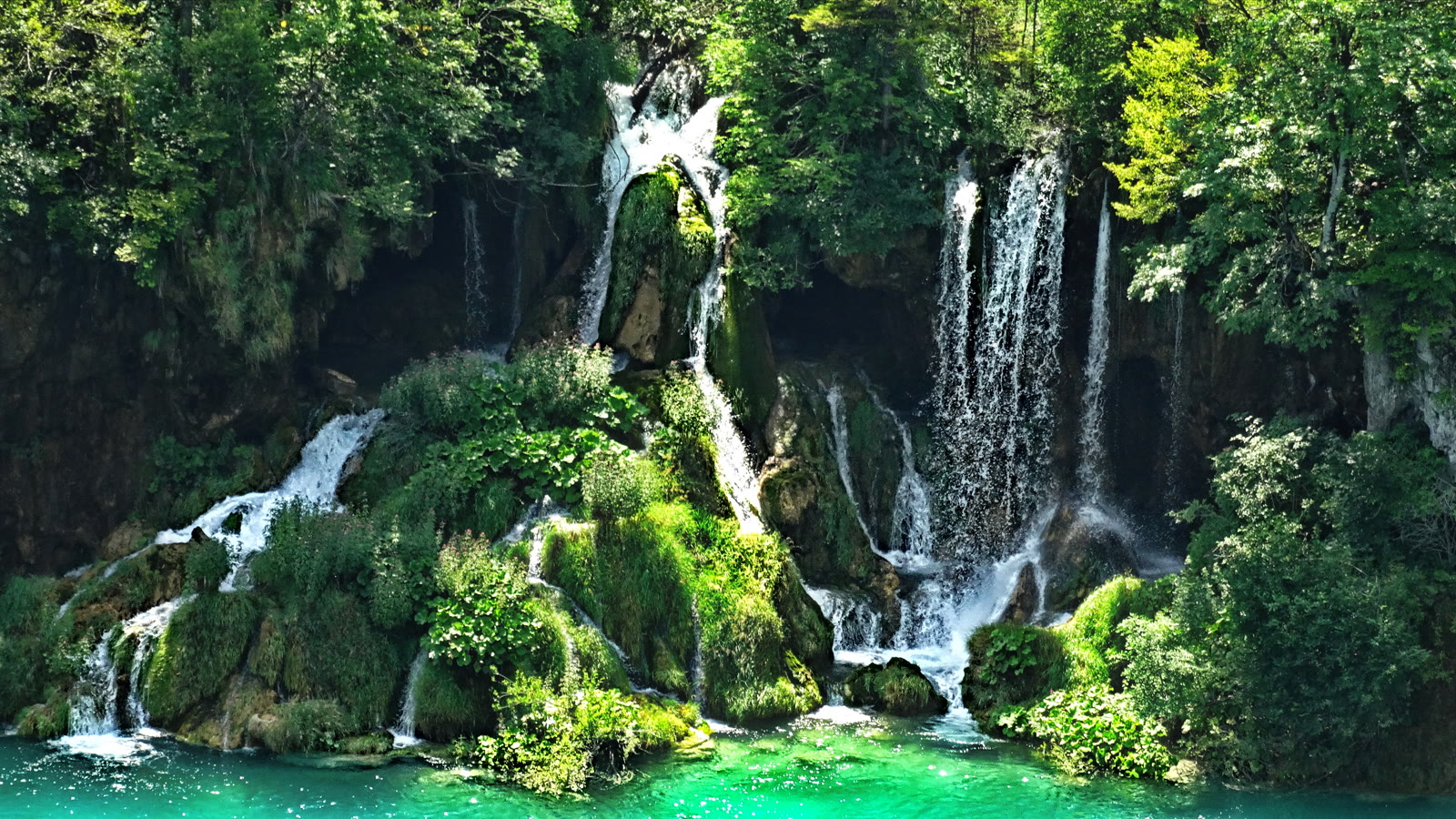 Vandfald mellem groenne skraenter ved Plitvice-soeerne