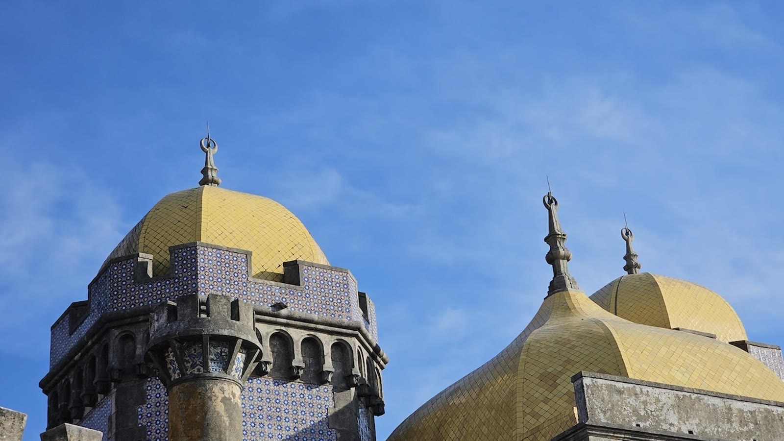 Pena-paladsets gule kupler og blaa kakler mod himlen i Sintra